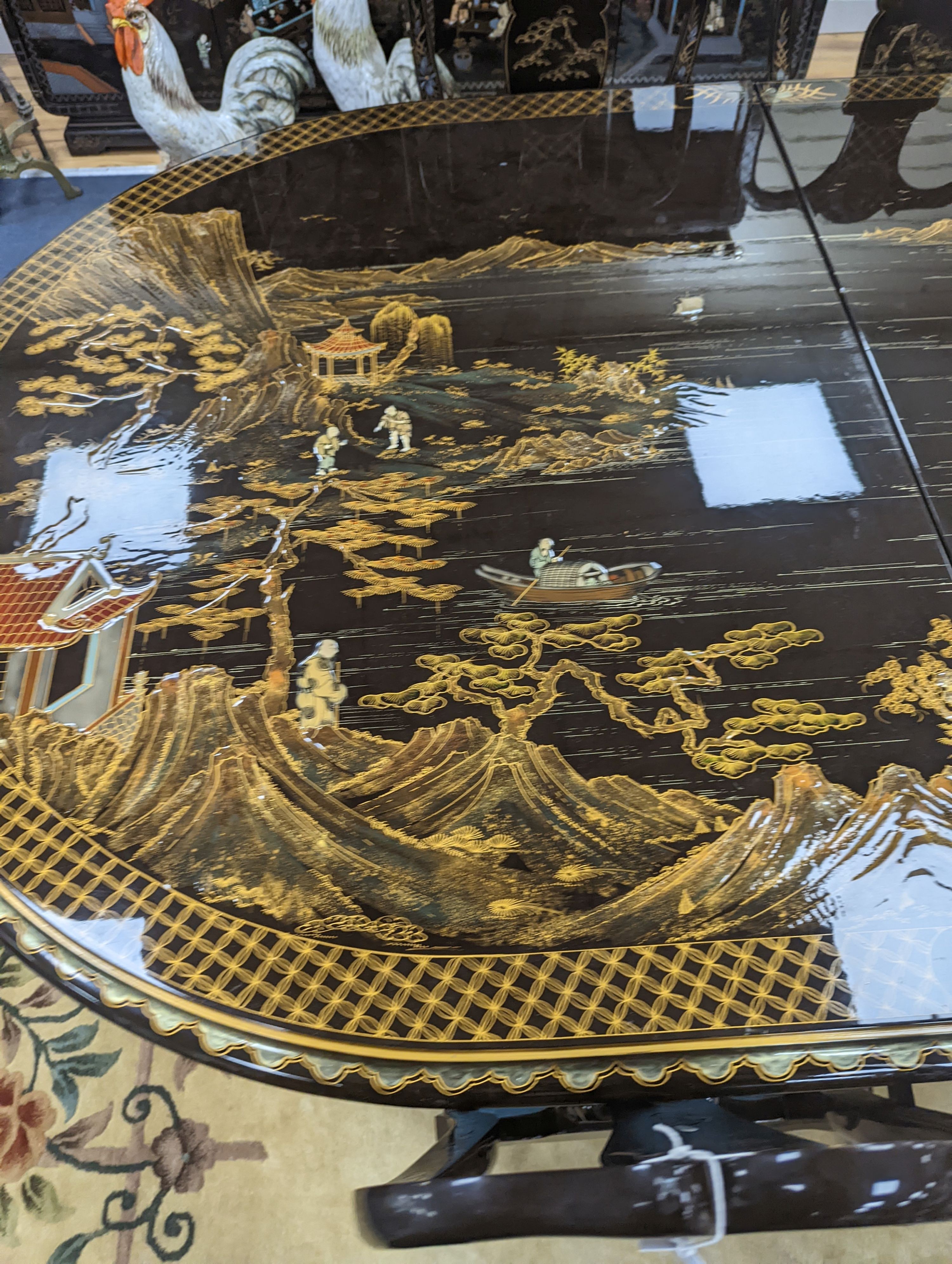 A Chinese lacquer decorated dining table and 12 chairs. Length -277cm, Depth- 120cm, Height - 74cm.